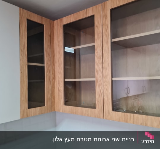 ארונות מטבח עליונים עם דלתות זכוכית ומסגרת עץ בהיר